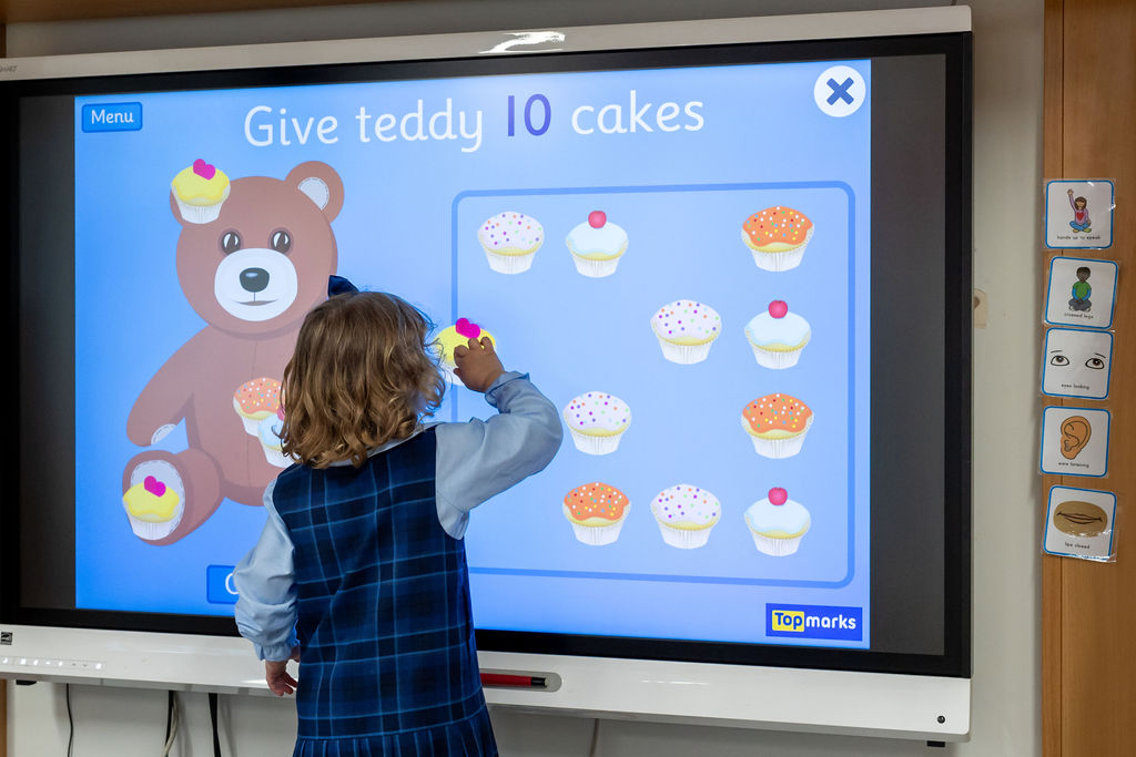 A child in Horris Hill's Lower School uses a smart whiteboard to learn