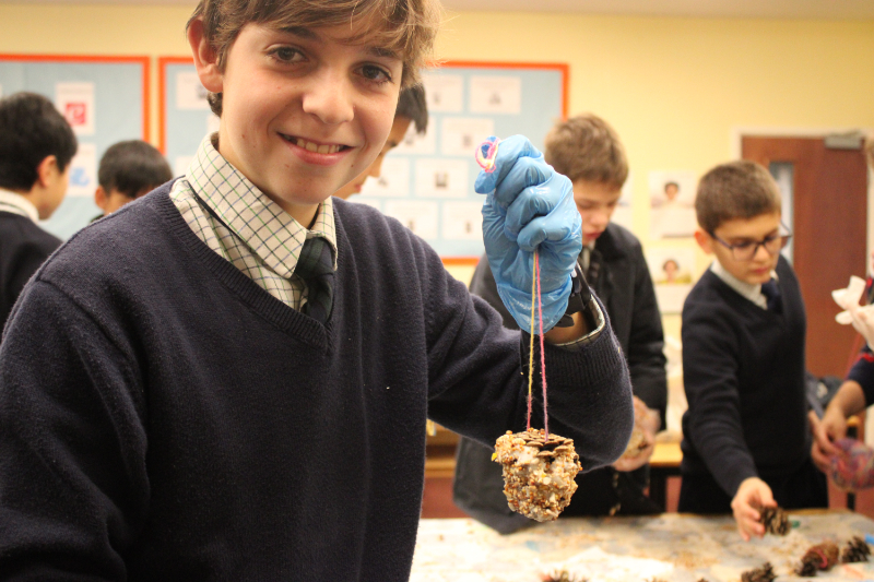 Year 8 student at Horris Hill School holding a handmade bird feeder