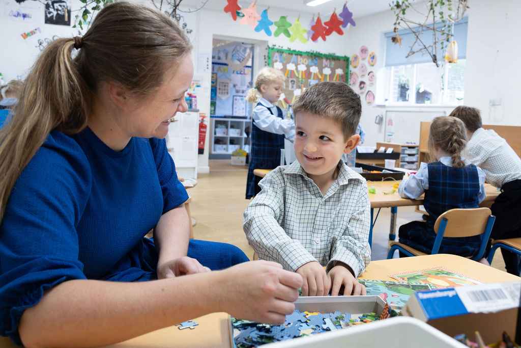 A child in Reception class at Horris Hill School works on a puzzle with the teacher